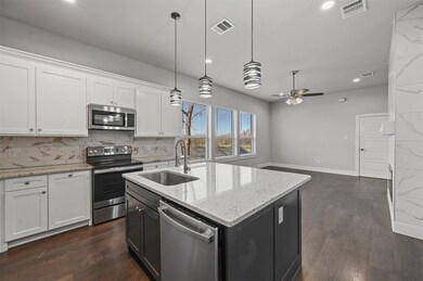 Kitchen featuring appliances with stainless steel finishes, ceiling fan, backsplash, white cabinetry, and dark hardwood / wood-style flooring