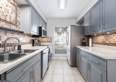 This kitchen features sleek gray cabinetry, modern