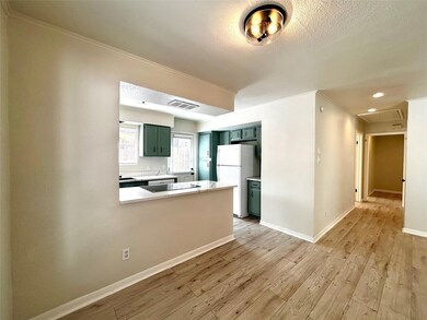 Kitchen featuring green cabinetry, light countertops, a peninsula, freestanding refrigerator, and light wood-type flooring