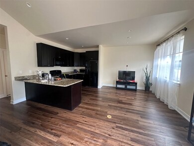 Kitchen featuring light stone countertops, black a