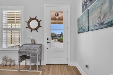 Doorway featuring wood finished floors and baseboa