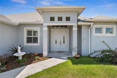 View of exterior entry featuring a shingled roof, 