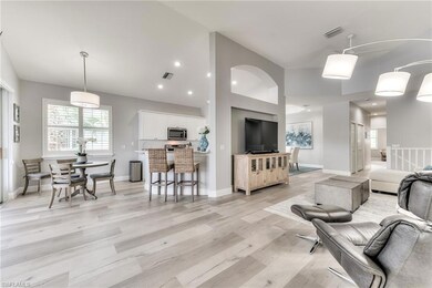 Living room with light hardwood / wood-style floors and a high ceiling