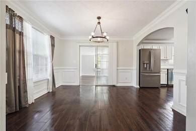 Unfurnished dining area with arched walkways, dark
