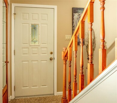 Front entry offers warm wood rails and complementi