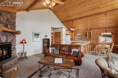 Living area featuring light colored carpet, wood ceiling with exposed beams, high vaulted ceiling, ceiling fan, and baseboards