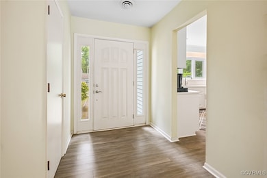 Entryway with dark wood-style flooring and baseboa
