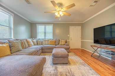 Living room featuring ornamental molding, a wealth