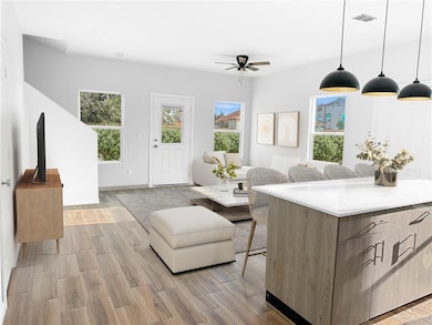 Living area featuring wood tiled floors and ceiling fan