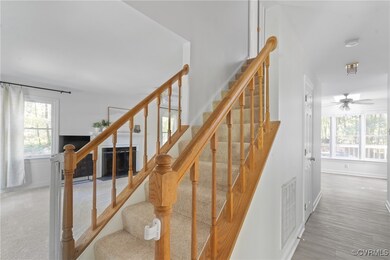 Stairs with carpet flooring and ceiling fan