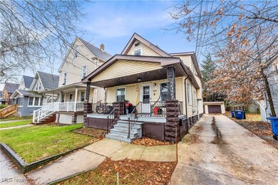 View of front of property with an outbuilding, a porch, a garage, and a front yard