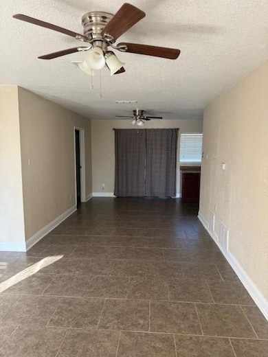Spare room with a textured ceiling and baseboards