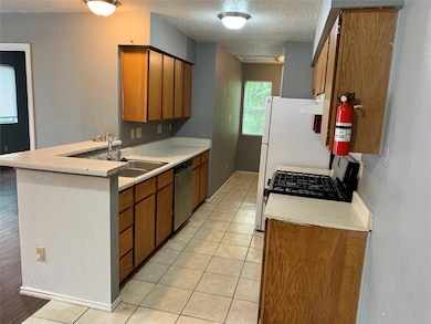Kitchen with light countertops, light tile patter