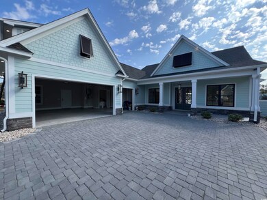View of front facade featuring a garage and covere