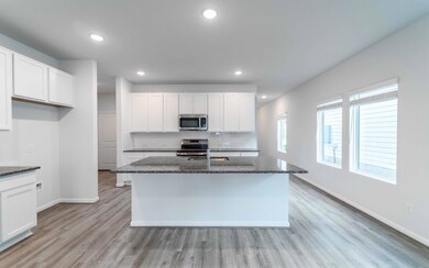 Kitchen with dark stone counters, white cabinetry
