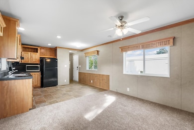 Kitchen featuring plenty of natural light, light colored carpet, freestanding refrigerator, crown molding, and recessed lighting