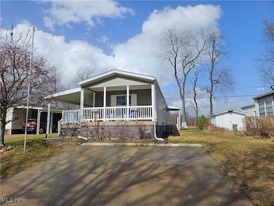 View of front of property with central air condition unit, a front lawn, a porch, and an attached carport