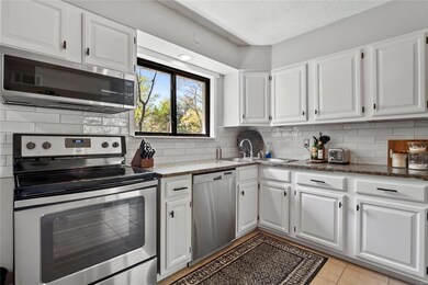 Bright kitchen with ganite counters, subway tile backsplash and newer Stainless Steele appliances.