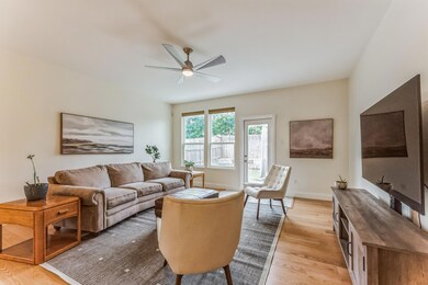 Living room with ceiling fan and light hardwood / 