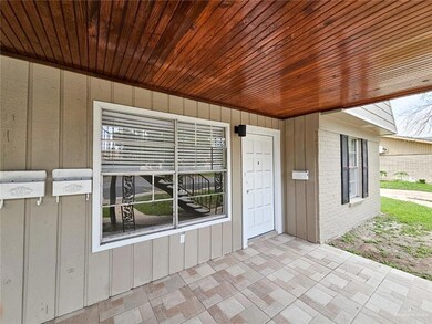 View of exterior entry featuring board and batten siding and brick siding