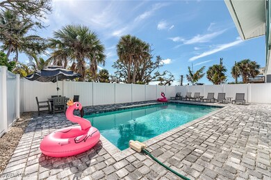 View of pool featuring a patio area, a fenced backyard, and outdoor dining space- Virtually Edited Image