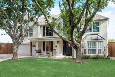 View of front of house with a porch, a garage, and a front lawn