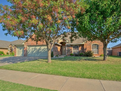 View of front facade with a front yard, concrete driveway, a garage, and brick siding