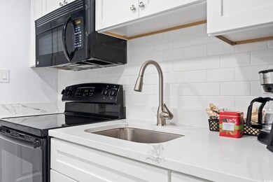 Kitchen featuring white cabinetry, sink, tasteful 
