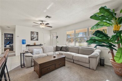 Living room featuring ceiling fan, light colored c