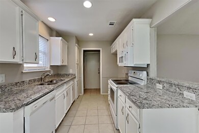 Kitchen featuring white cabinets, light tile patte