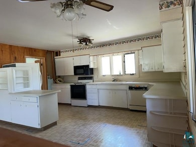Kitchen featuring white appliances, light countertops, white cabinetry, ceiling fan, and open shelves