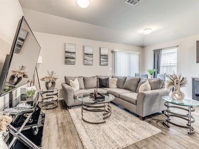 Living area with wood finished floors, vaulted ceiling, and baseboards
