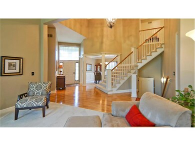 Entry with hardwoods, chandelier, and high ceiling