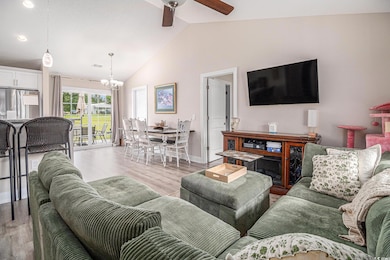 Living room with ceiling fan, light wood-type floo