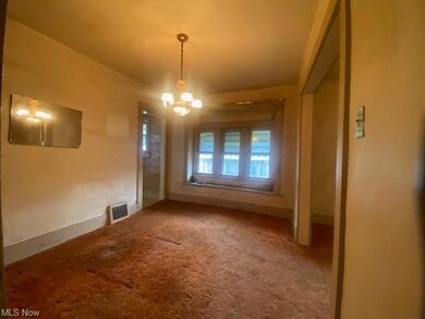 Carpeted empty room with a notable chandelier