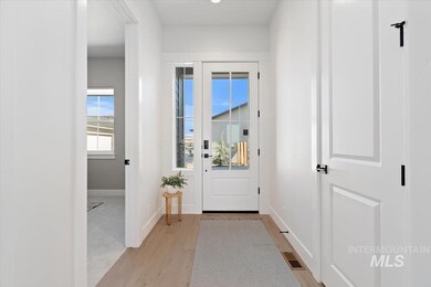 Doorway to outside with light wood-style floors and baseboards