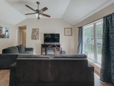 Tiled living room featuring vaulted ceiling and ceiling fan