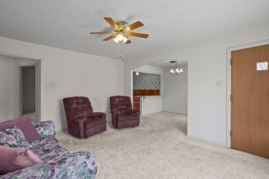 Living room with baseboards, a textured ceiling, a