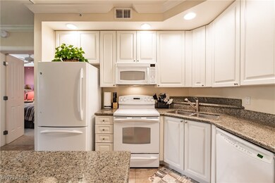 Kitchen with white cabinets, white appliances, sin