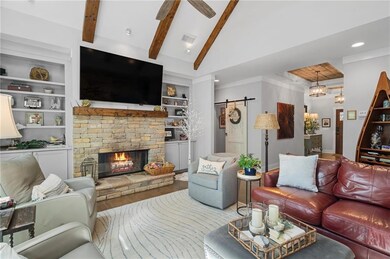 Living area with wood finished floors, a barn door, a fireplace, recessed lighting, and a ceiling fan