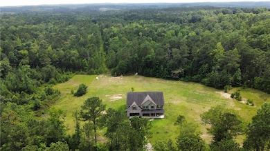 Aerial view of property and surrounding area featuring a heavily wooded area