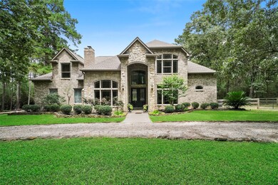 Front of the house showing full brick and stone exterior, double 8' entry doors, and circle drive.