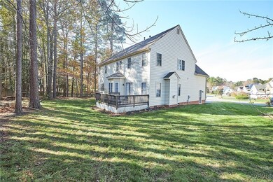 Rear view of property featuring a lawn and a woode