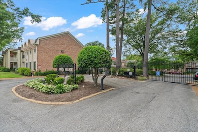 View of asphalt street featuring a gate and a gated entry