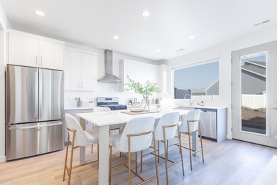 Kitchen featuring appliances with stainless steel finishes, a kitchen island, light wood finished floors, wall chimney exhaust hood, and recessed lighting