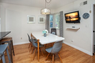 The dining room fittingly adjoins the kitchen and with its glistening windows, lighted ceiling fan, chic drop-down lighting and hardwood floors it is perfect for any occasion.