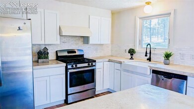 Kitchen with sink, backsplash, custom range hood, 