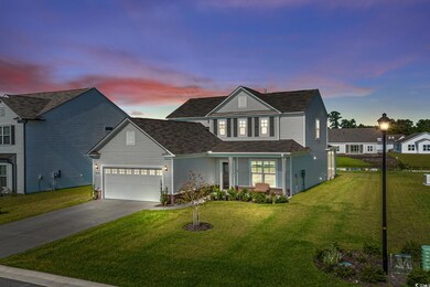 Front of property with a garage and a lawn