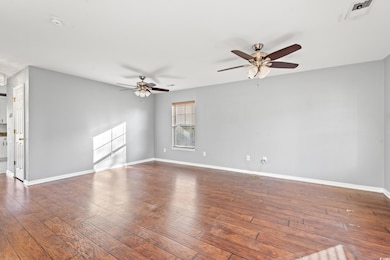 Empty room with ceiling fan and dark wood-type flo