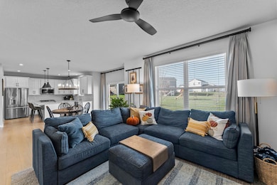 The welcoming living room showcases a Heat & Glo gas fireplace with a stone surround and large picture windows that fill the space with natural light.